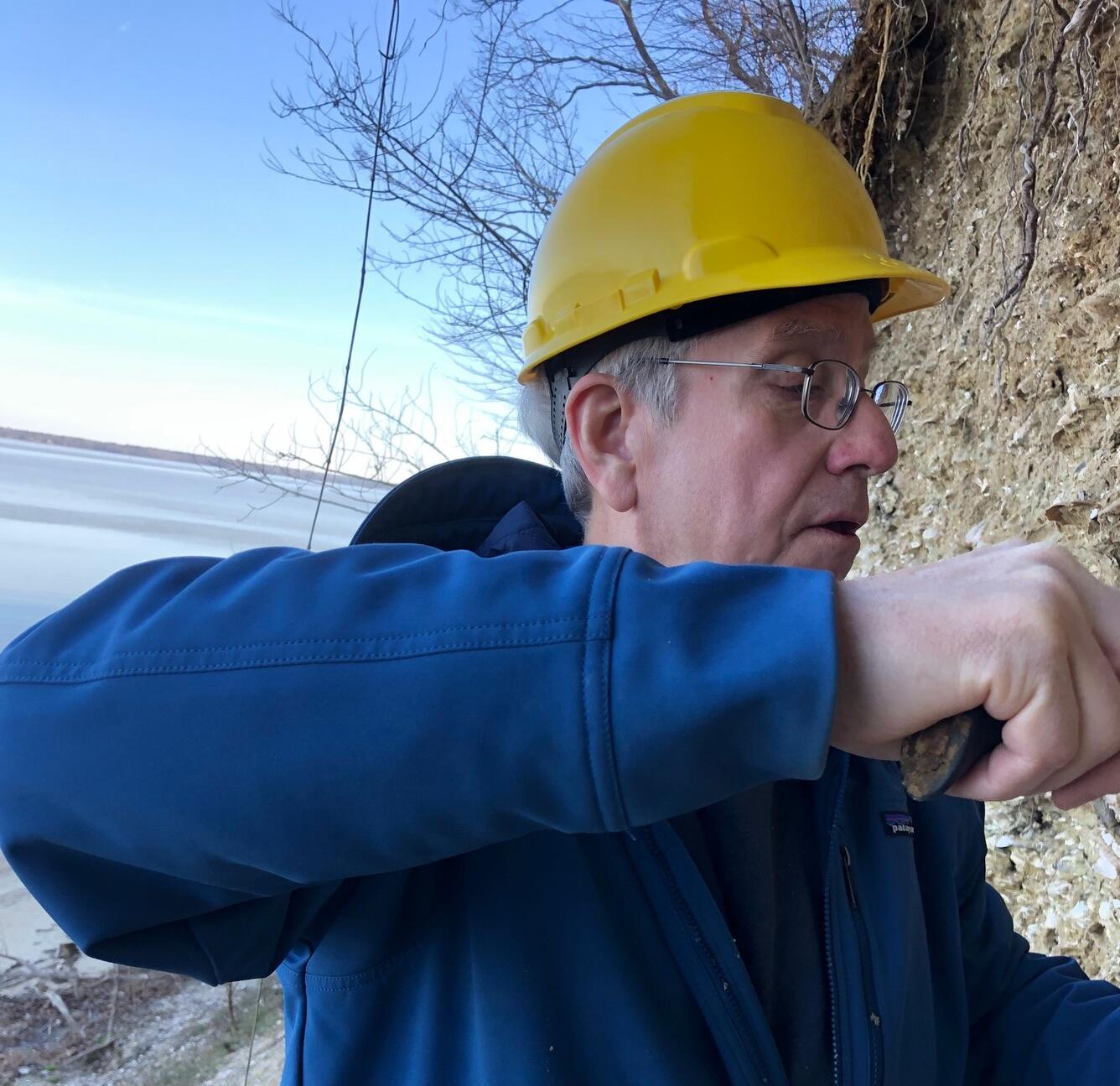 Kevin Foley collects a sample from an outcrop