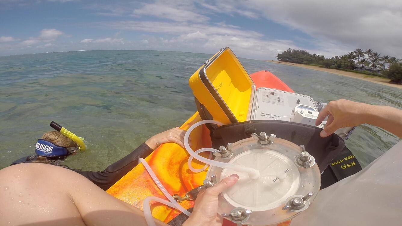 collecting water samples while onboard a kayak