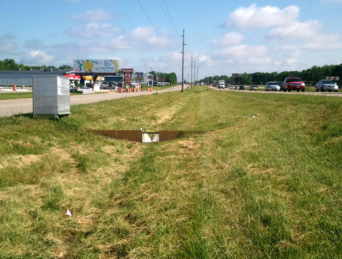 Photo of water-quality sampling in a grass swale on a divided highway