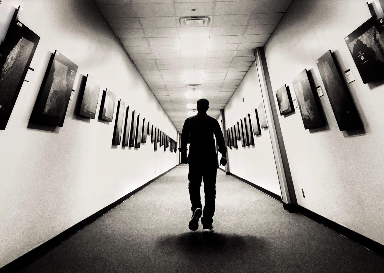 Black and white photo of USGS  EROS staffer walking through Hall of States