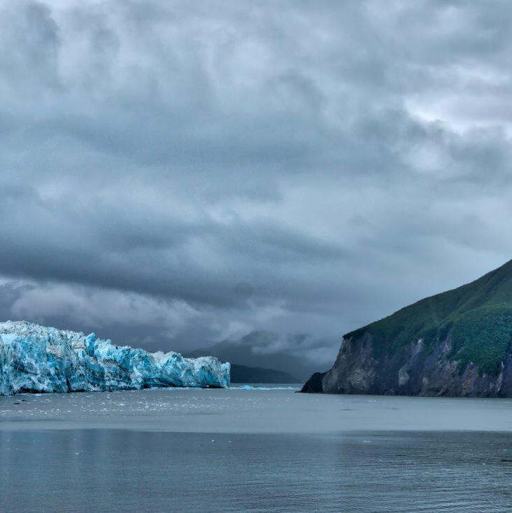 Panorama of Alaskan coastline with Hubbard Glacier on the left and hills on the right