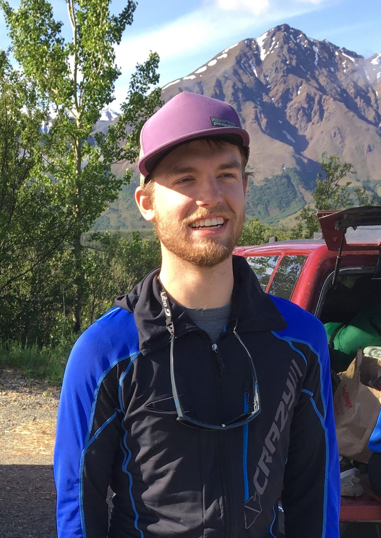 Photo of hydrotech Abraham Meyerhofer standing in front of mountain.