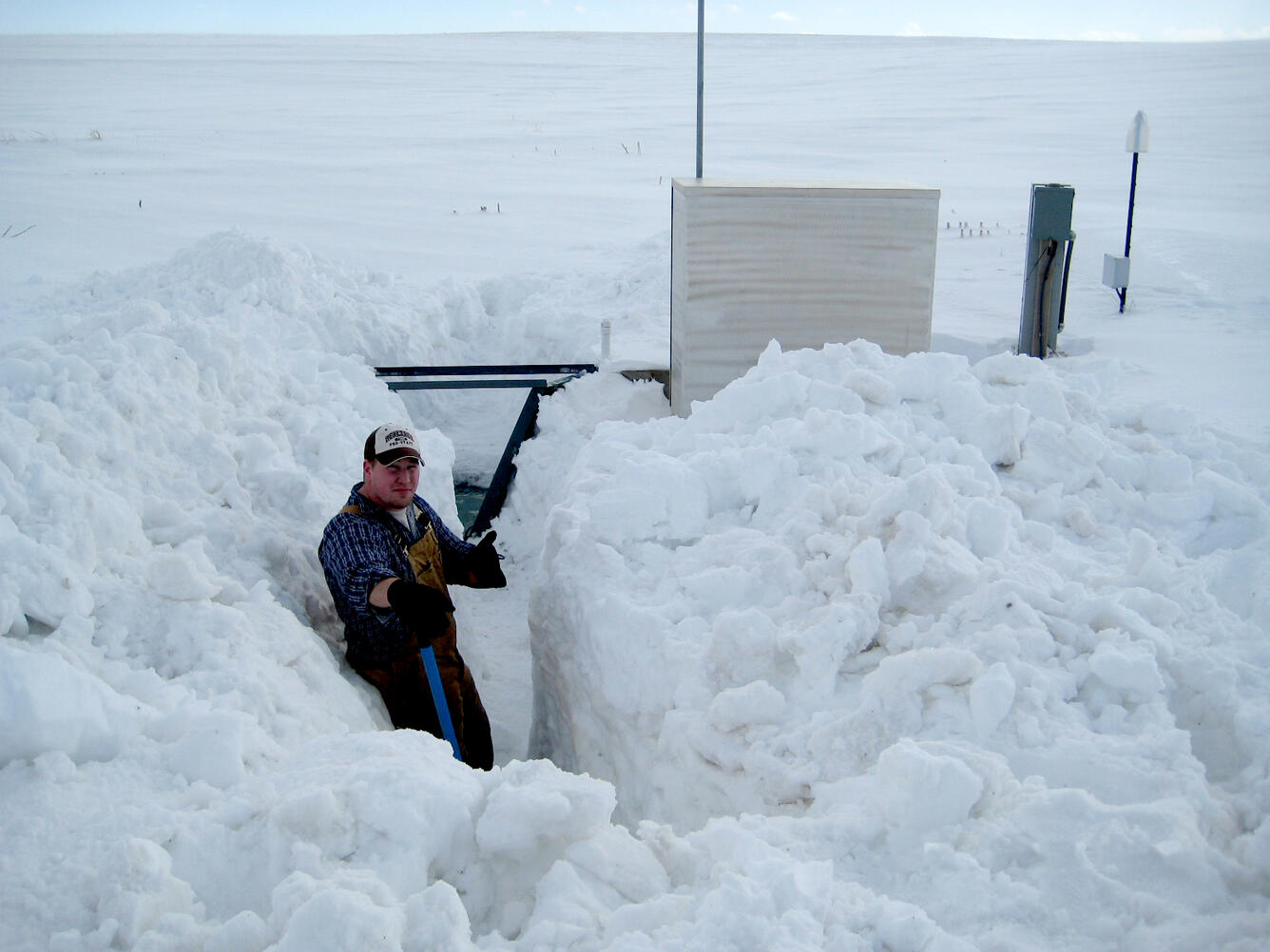 Photo showing WI WSC employee digging out an edge-of-field station during winter monitoring.