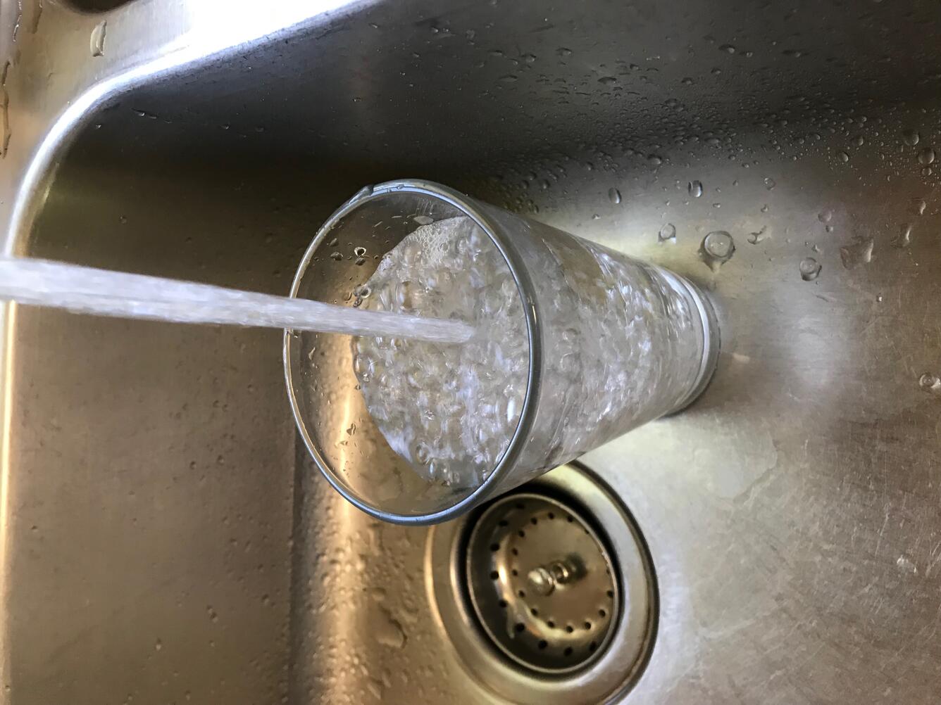 kitchen sink water flowing into glass