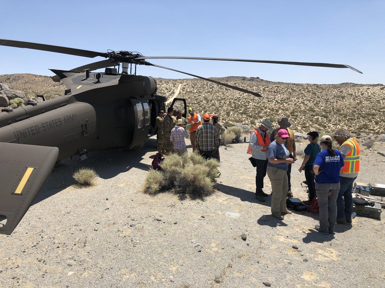 Image shows several people standing next to a helicopter