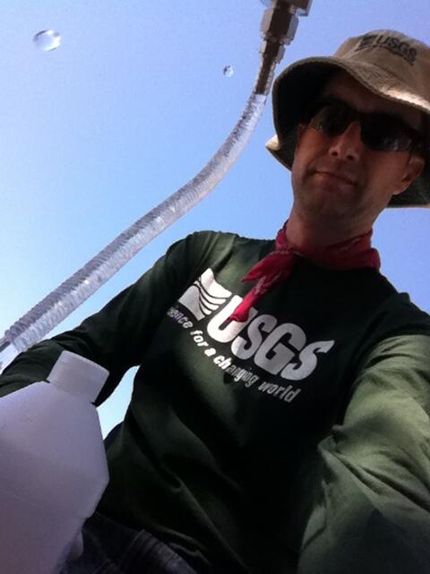 Photo of Hydrologic Technician, Timothy Mathany, holding a sample bottle.