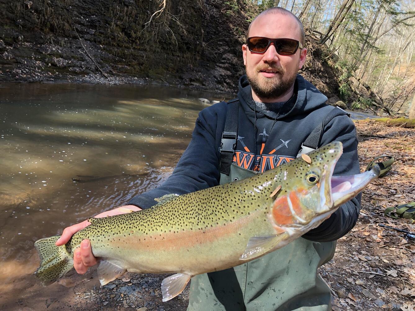 Photo of Research Fisheries Biologist, Joseph Schmitt, holding a Lake Erie steelhead.