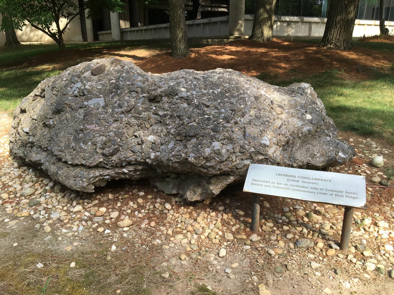 Image shows a large gray stone with a plaque nearby