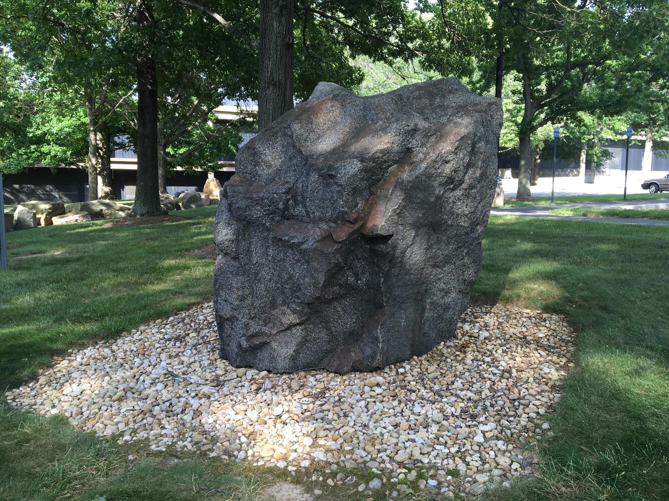 Image shows a large black stone on a bed of gravel