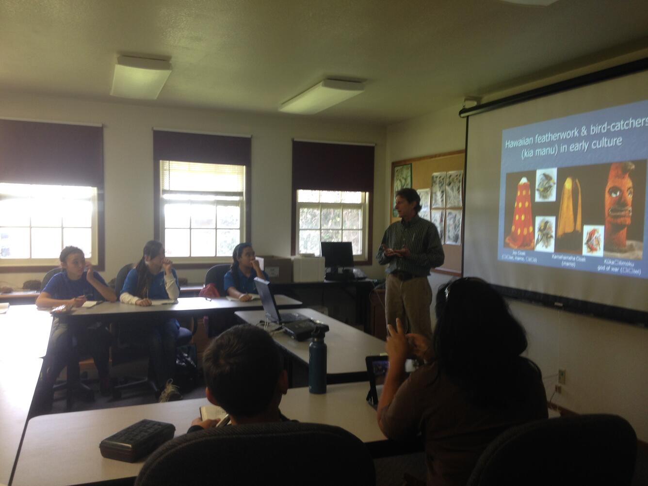 Paul Banko teaches children about the cultural significance of Hawaiian bird feathers