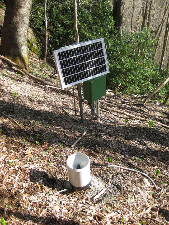 Monitoring station in Coweeta Experimental Forest surrounded by trees on the side of a hill slope