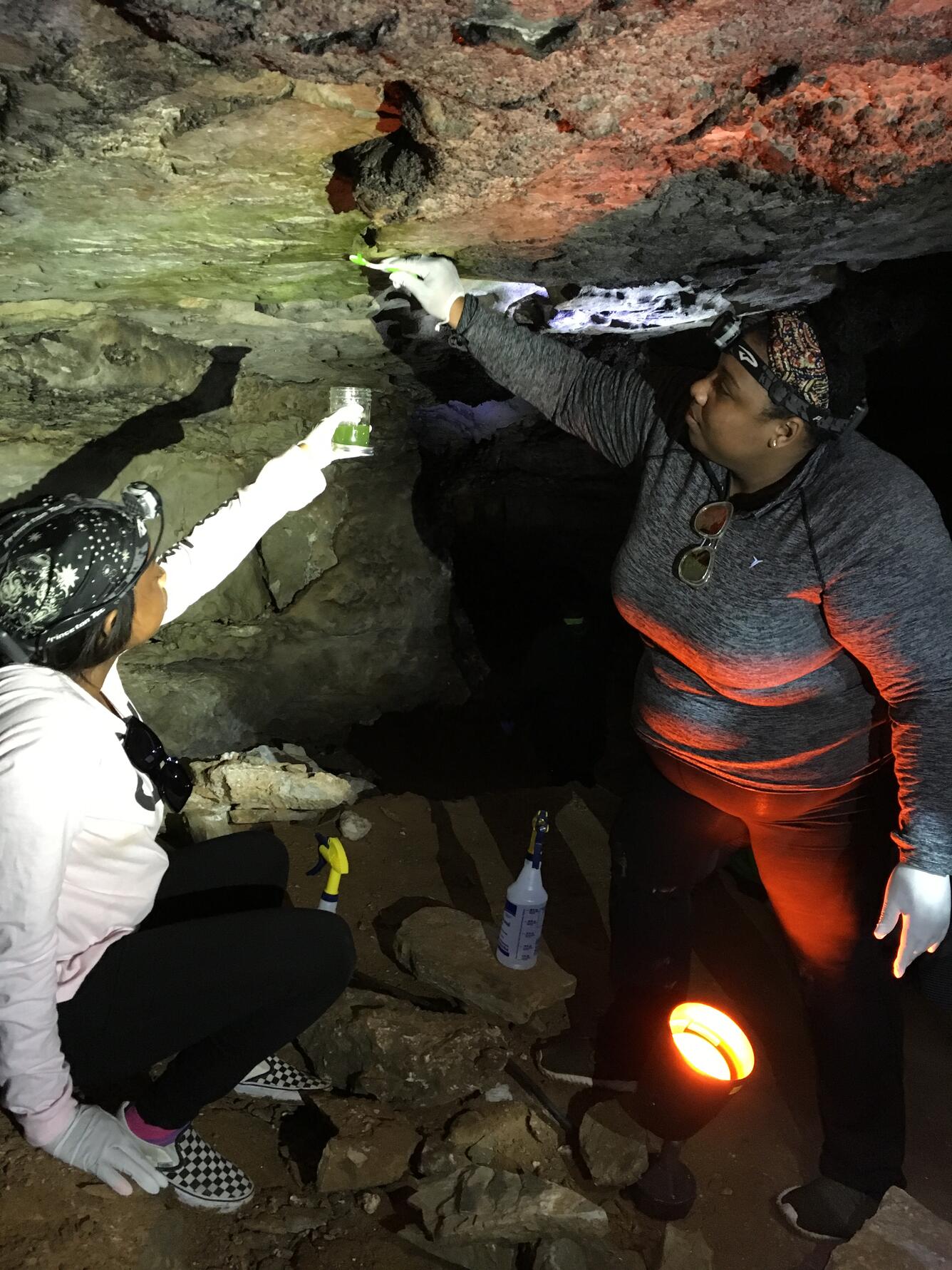 Graduate students collecting bacteria samples in a cave