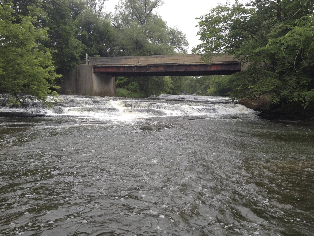 water rapids flowing under a bridge