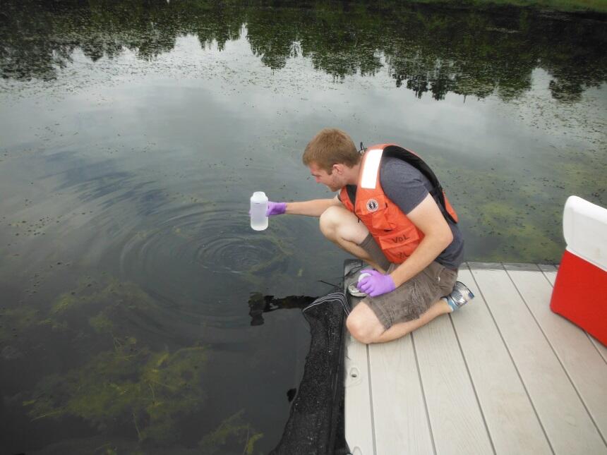 Researcher collecting water samples for eDNA analysis
