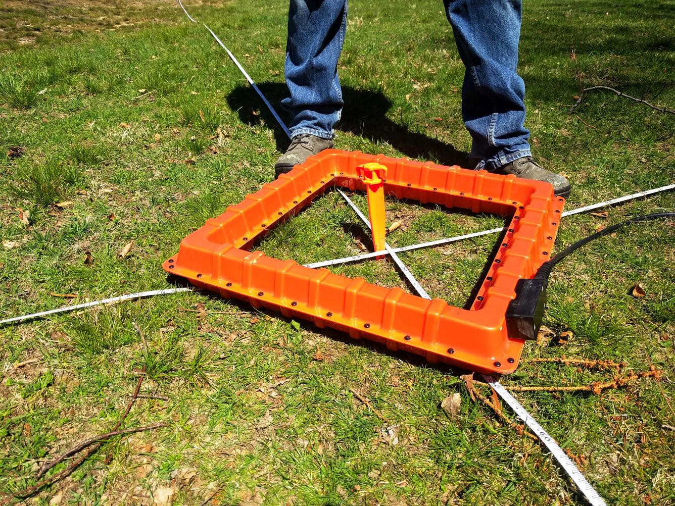 hollow orange square over marker on grass covered ground