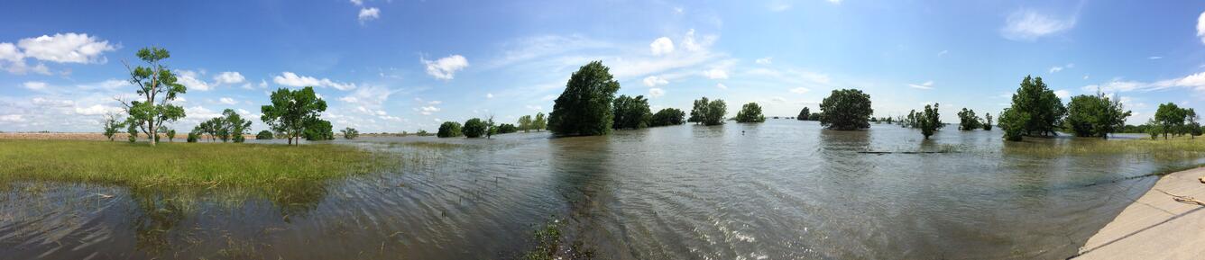 Panoramic Photo of a flood inundated area near John Redmond Reservoir. The water reaches the branches of moderately sized trees.