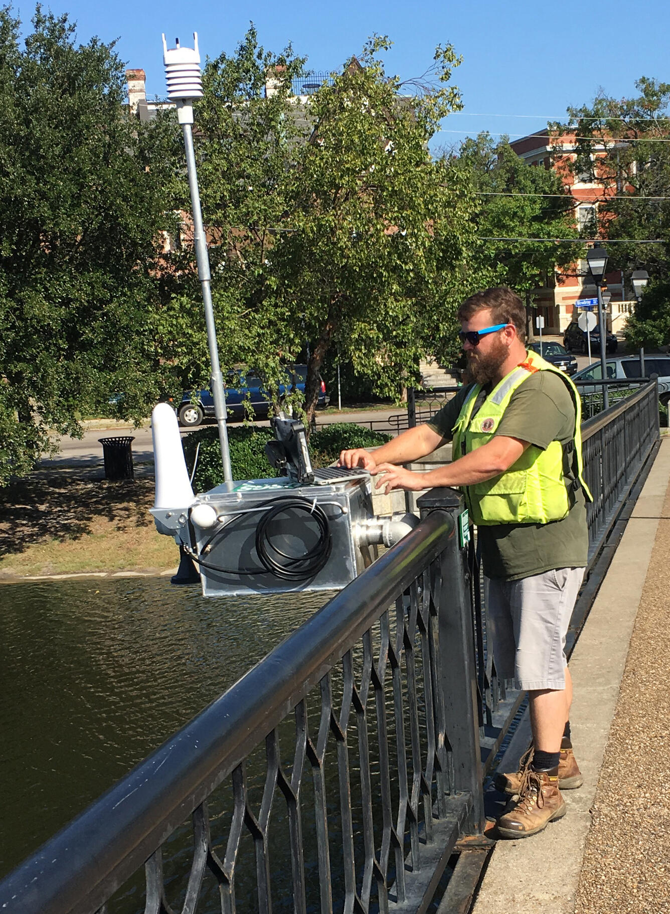 A USGS hydrologic technician installs a Rapid-Deployment Gauge on a bridge in Norfolk, Virginia.