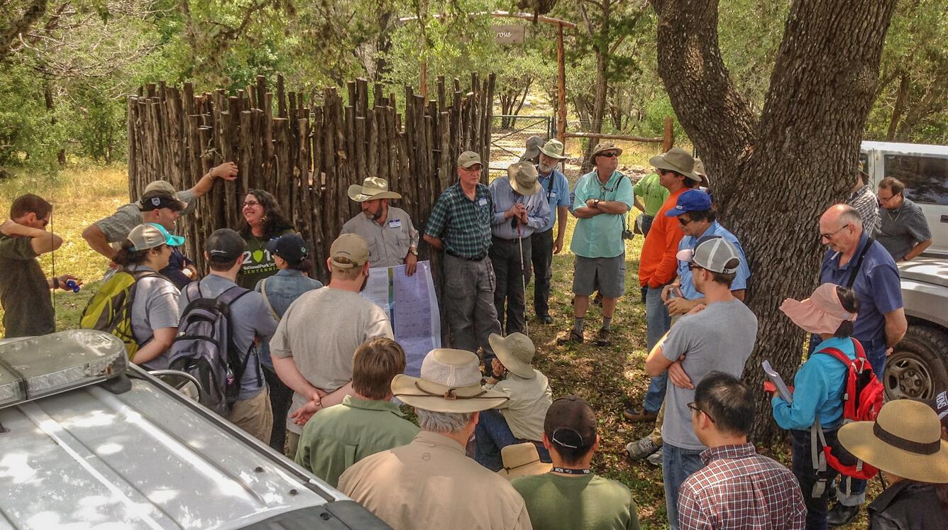 Attendees gathered in the shade at the edge of the parking lot.   Trail leading to the Narrows is visible in the background.
