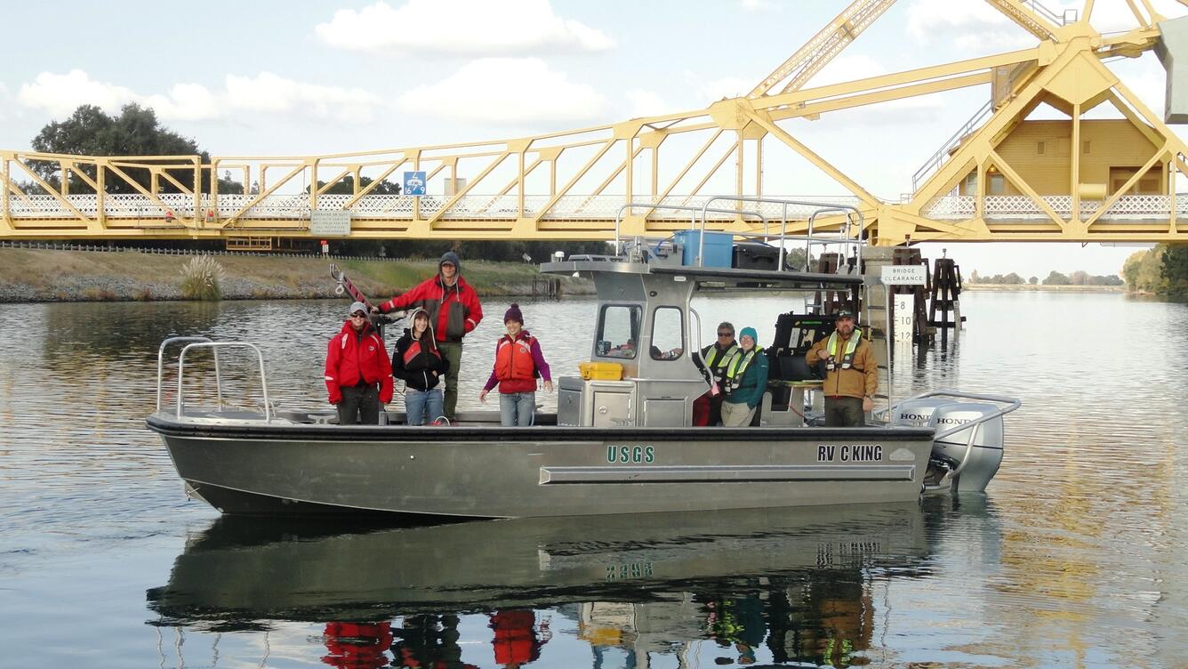 USGS scientists aboard the R/V King on the Sacramento River with the Walnut Grove Bridge in the background.