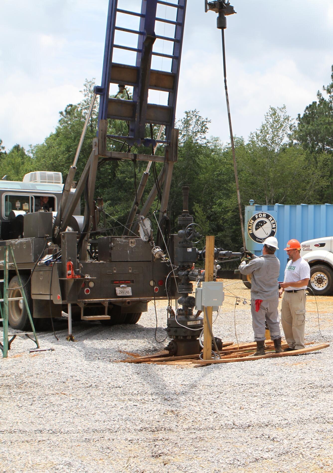 two men and a drill rig