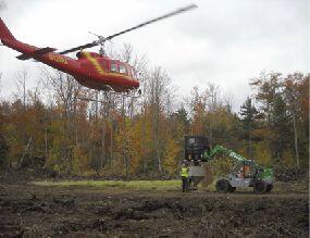 helicopter flying low dropping lime on forested land