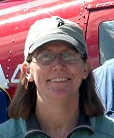 Lee Tibbitts standing in front of a helicopter 