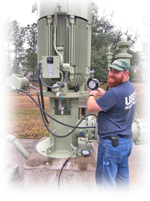 USGS hydrologic technician measuring a well