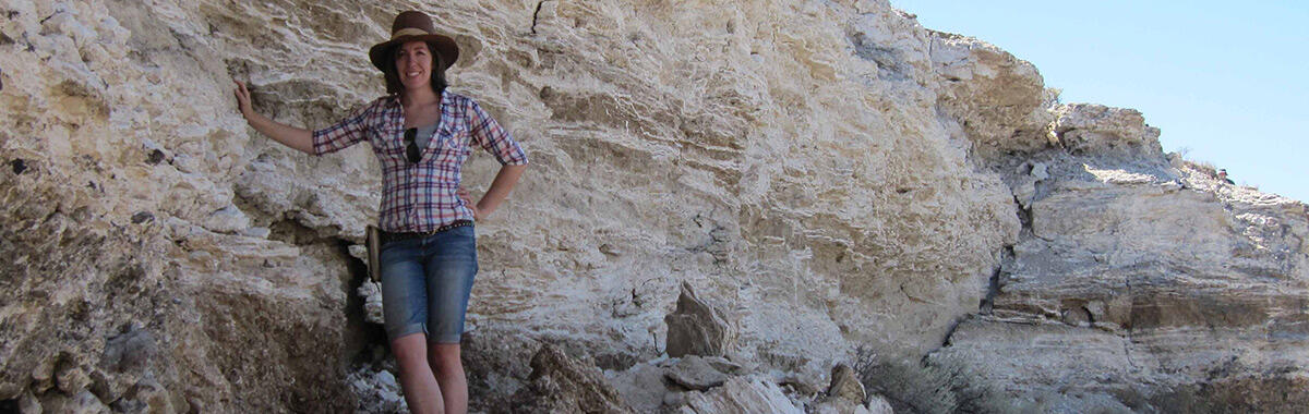 person standing next to white rocky ridge