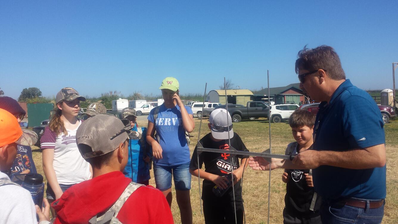 Photo of a USGS scientist showing kids how telemetry works.