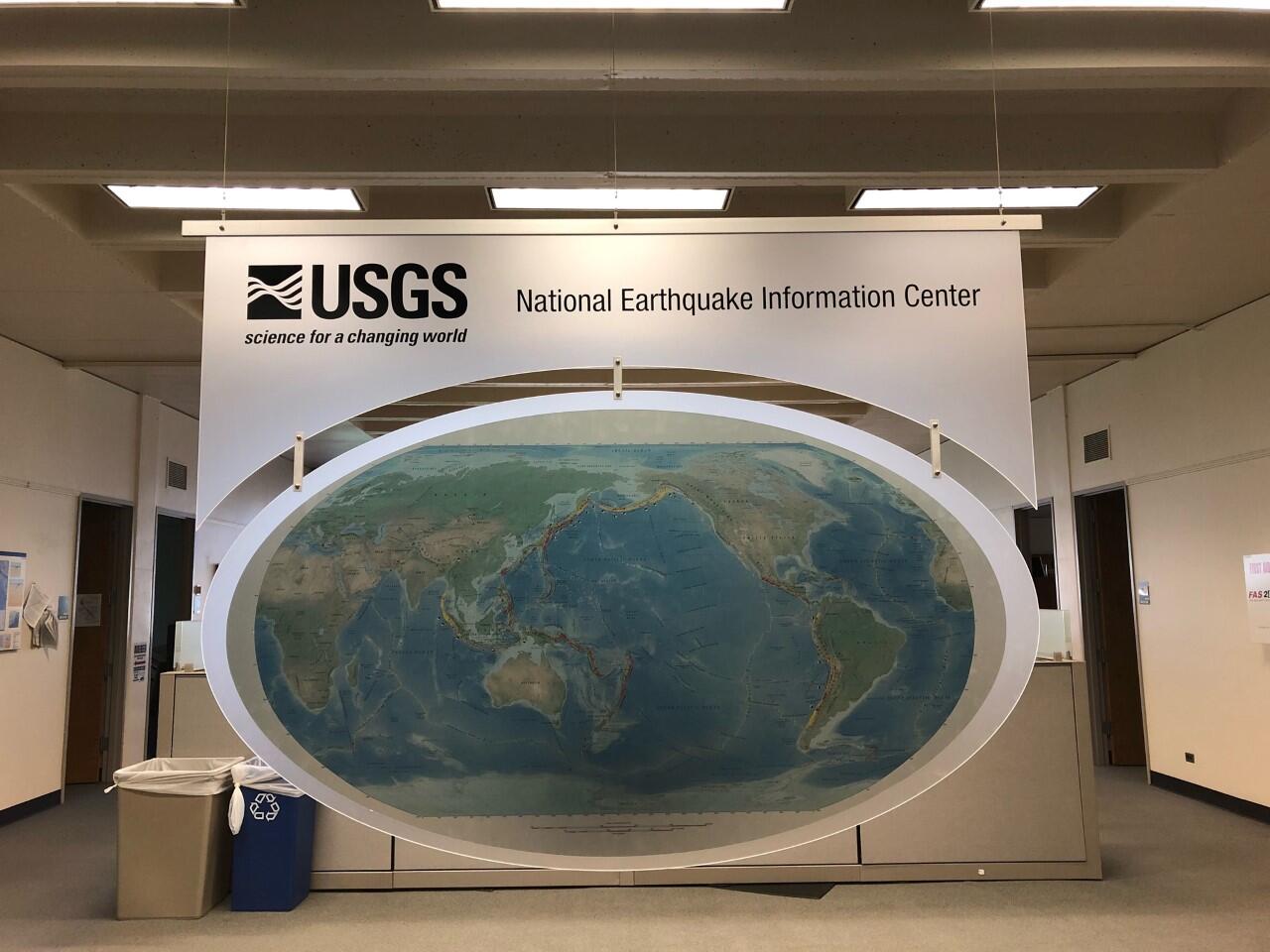 lit USGS logo sign with flat image of globe beneath it