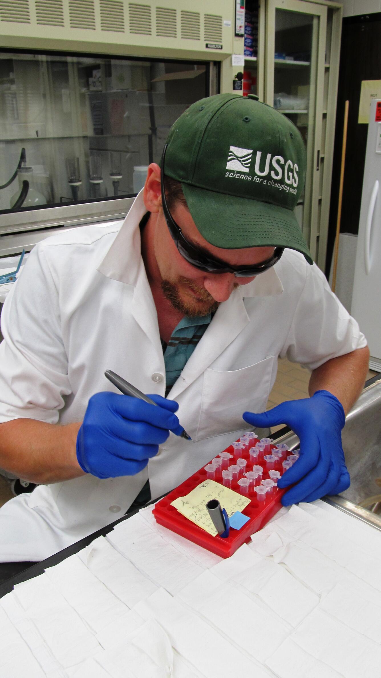 USGS Scientist Nate Jensen labeling eDNA samples taken from barge