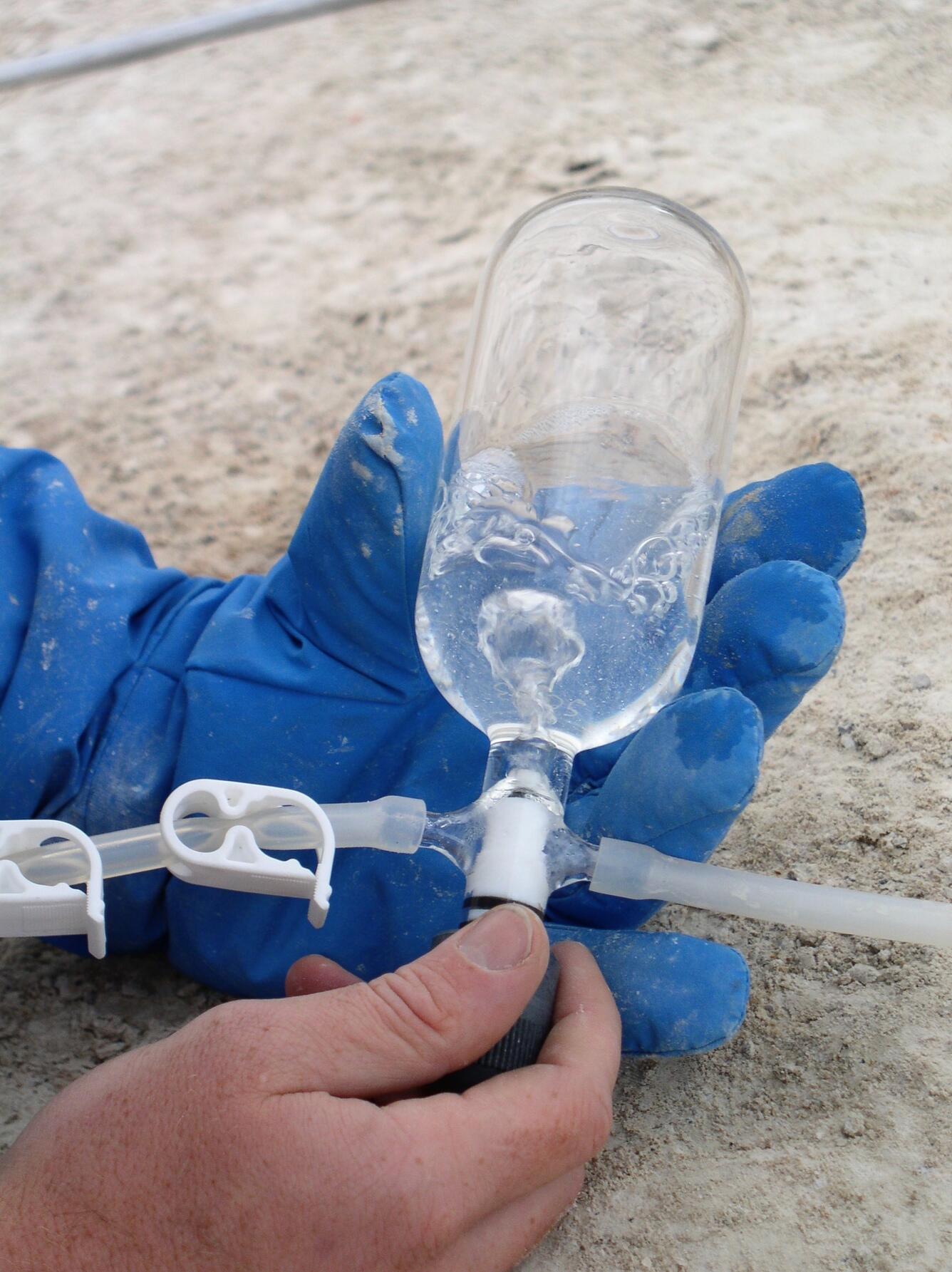 Gas bubbles through a sample bottle containing alkaline solution