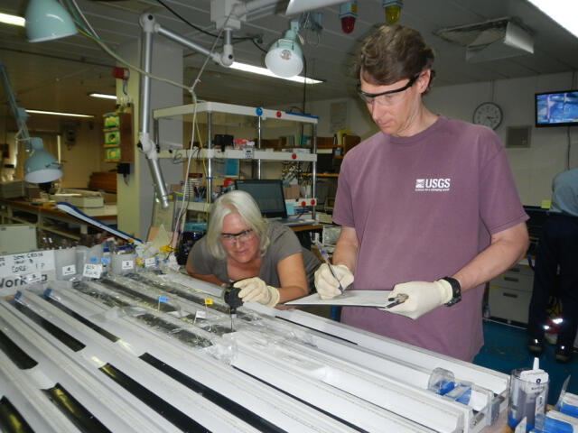 Image shows two researchers analyzing gas hydrate cores