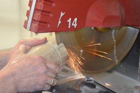 Rock core sample being cut on wet saw.