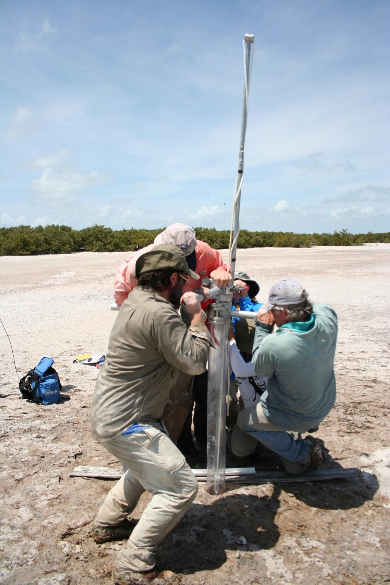 Researchers collecting a piston core from a Florida playa