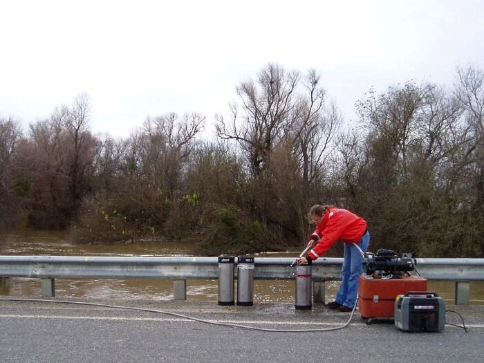 USGS scientist collecting a suspended sediment sample from the Yolo Bypass, California