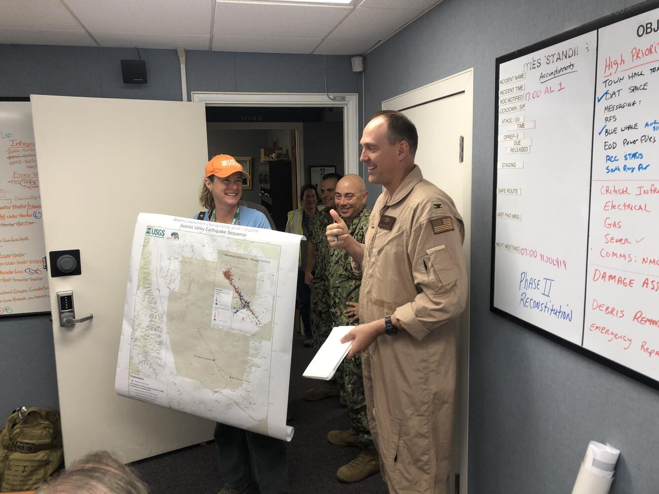 Woman holding map, standing next to man in military uniform