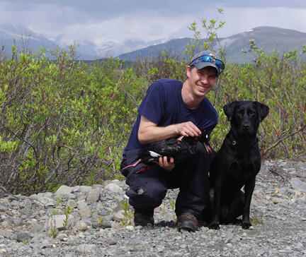Rob Wilson with his dog Abby holding a duck ready for specimen collection