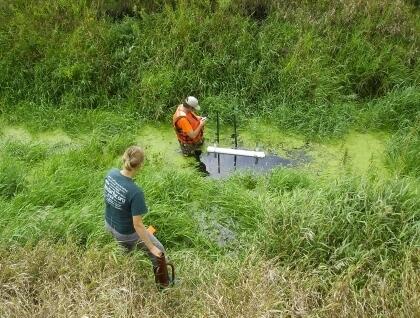 Two scientists install walling tubes in an agricultural drainage ditch