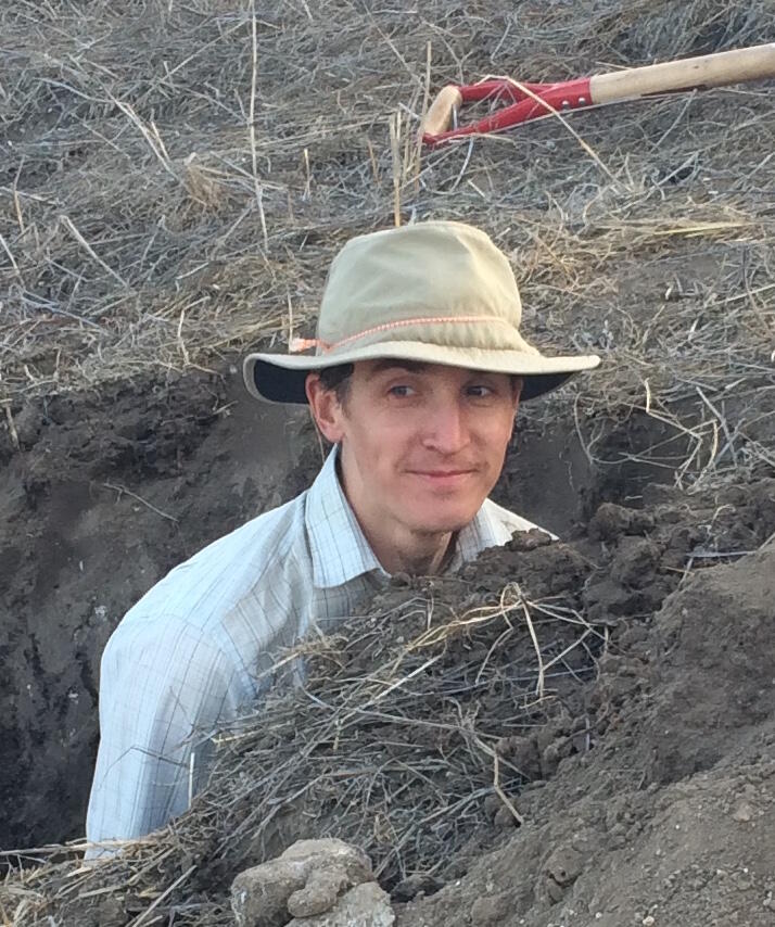 Photo of geologist, Sam Johnstone, in a soil pit