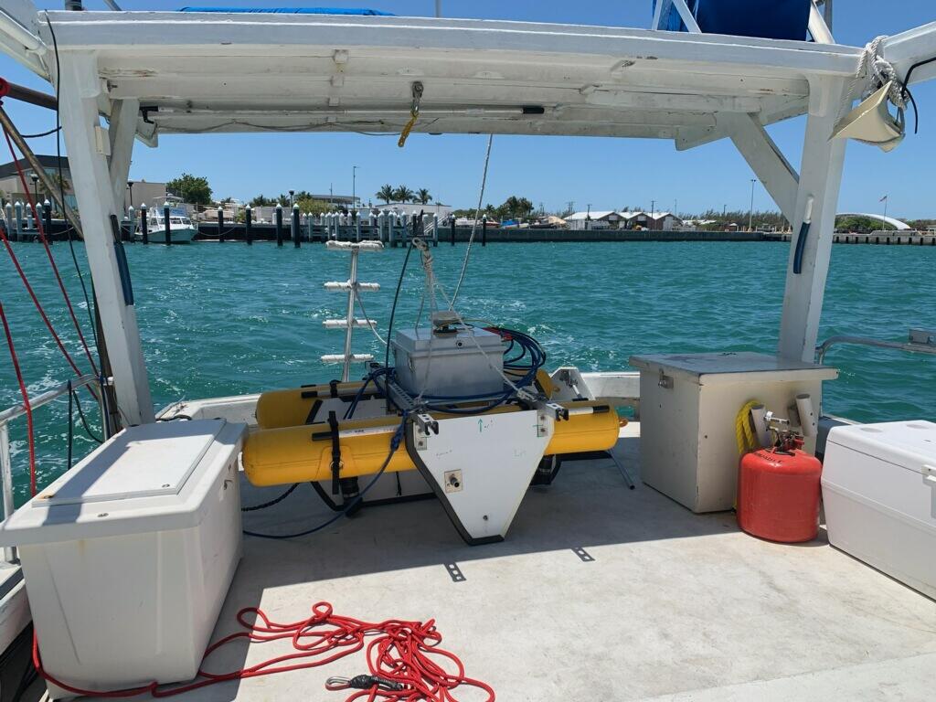 Scientific equipment on two yellow pontoons sits on the back deck of a research vessel