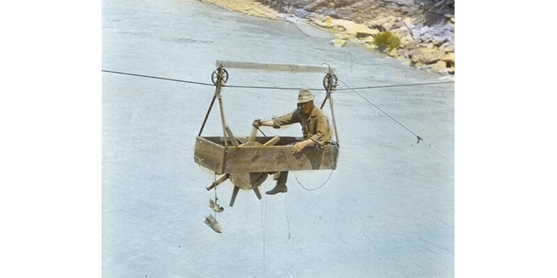 R.C. Pierce sits in hand-crafted cable car over San Juan River, Utah (circa 1915) 
