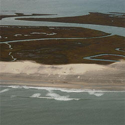 Aerial photograph of a wetland area behind a beach