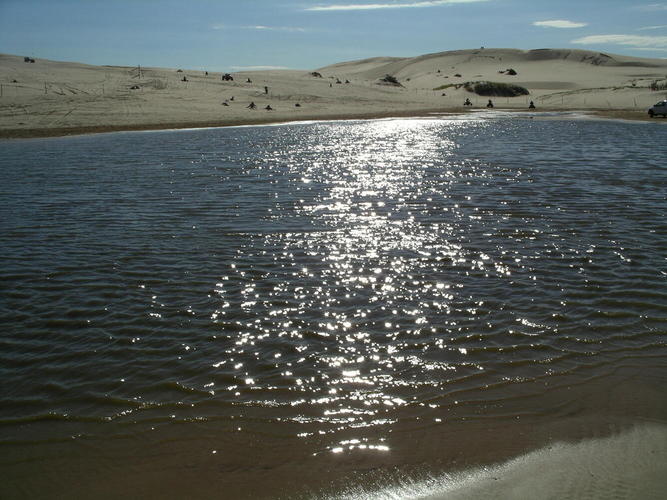View of Silver Lake and Sand Dunes, Michigan with sunlight reflecting off of lake.