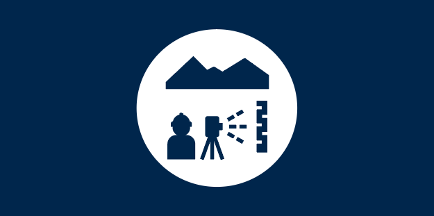 White circle on a navy blue background, with navy blue icons of a mountain and a scientist measuring in the field