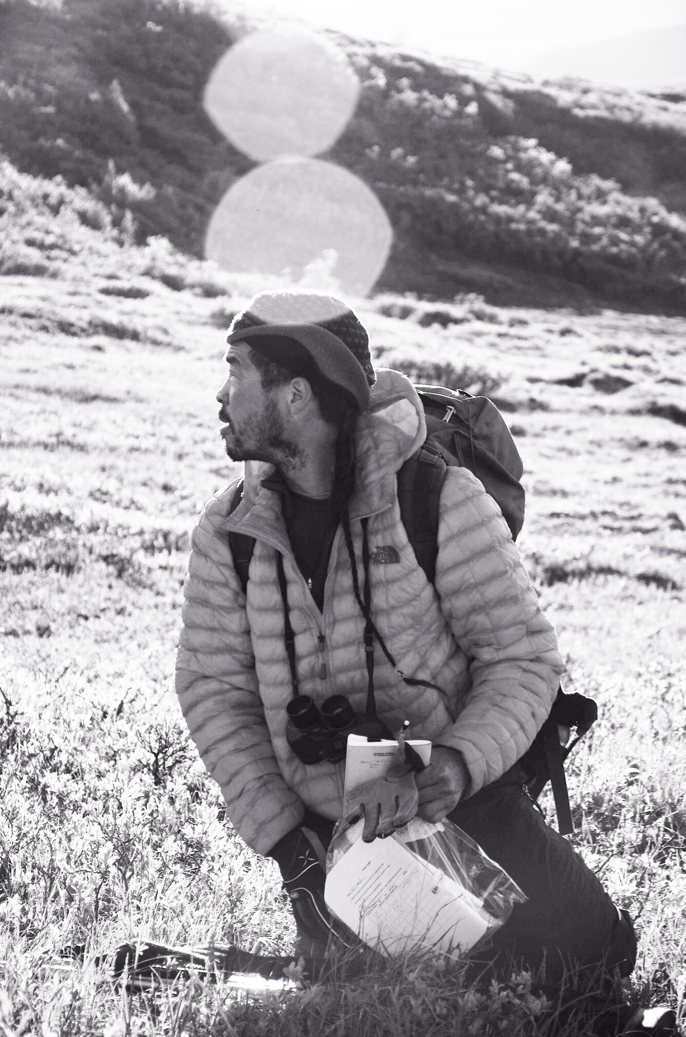 Steve Matsuoka putting field data notebooks in a plastic bag in an area where songbirds nest on the Seward Peninsula, Alaska