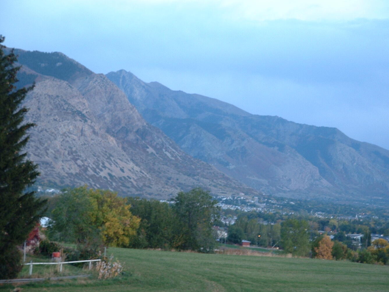 A landscape view from a residential area looking out at high peaks nearby