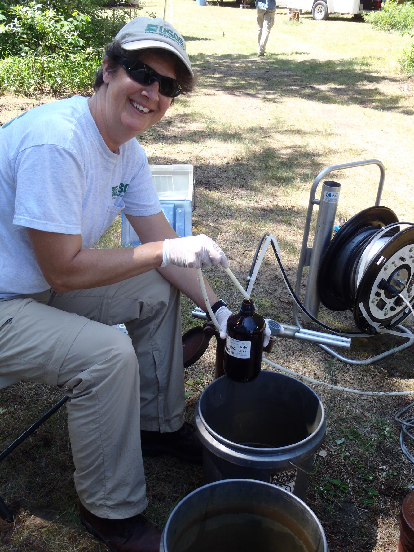 Mindy Erickson pours a tube containing a groundwater sample into a bottle.
