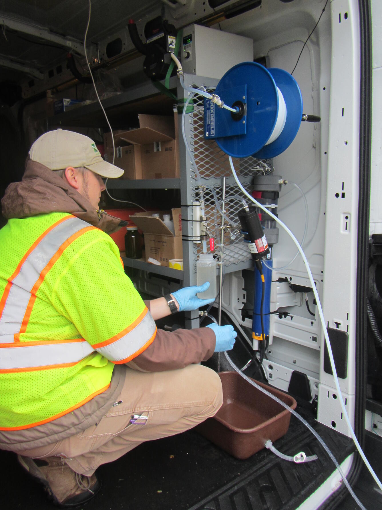 Photo of USGS scientist evaluating a sample inside a mobile water-quality sampling unit.