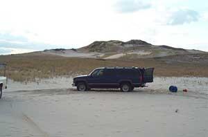 Vehicle parked on sand.